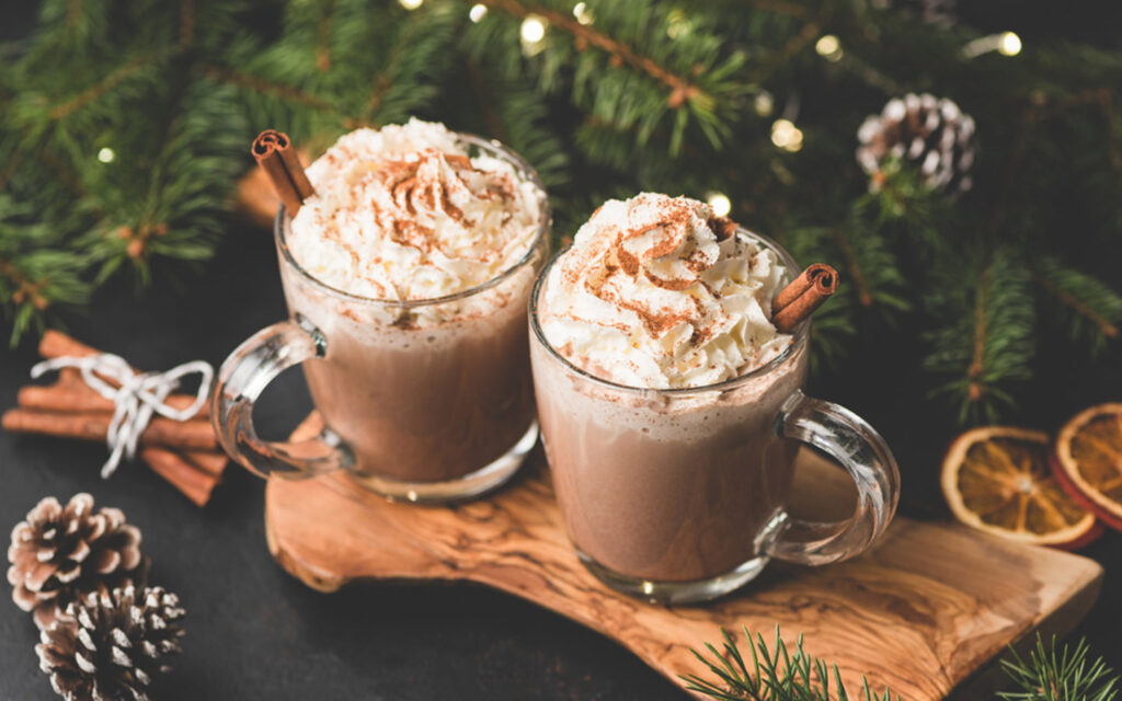 Two festive cups of hot chocolate topped with whipped cream and cinnamon in Dubai