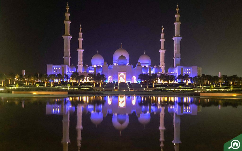 Sheikh Zayed Grand Mosque illuminated facade and reflecting pools at dusk