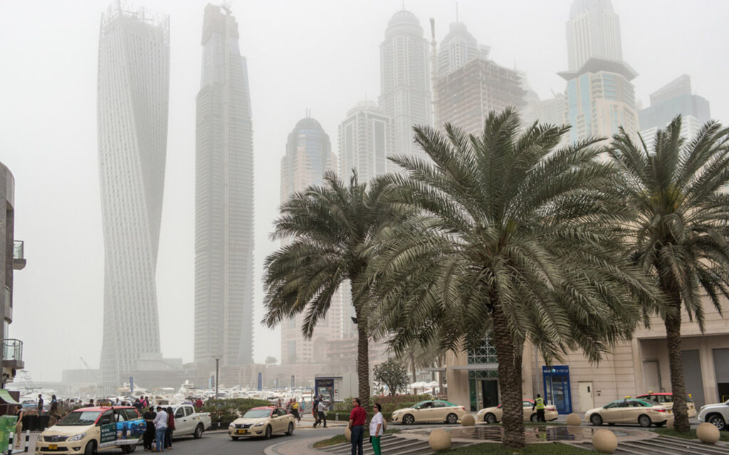 thick dust cloud enveloping urban streets during a Dubai sandstorm