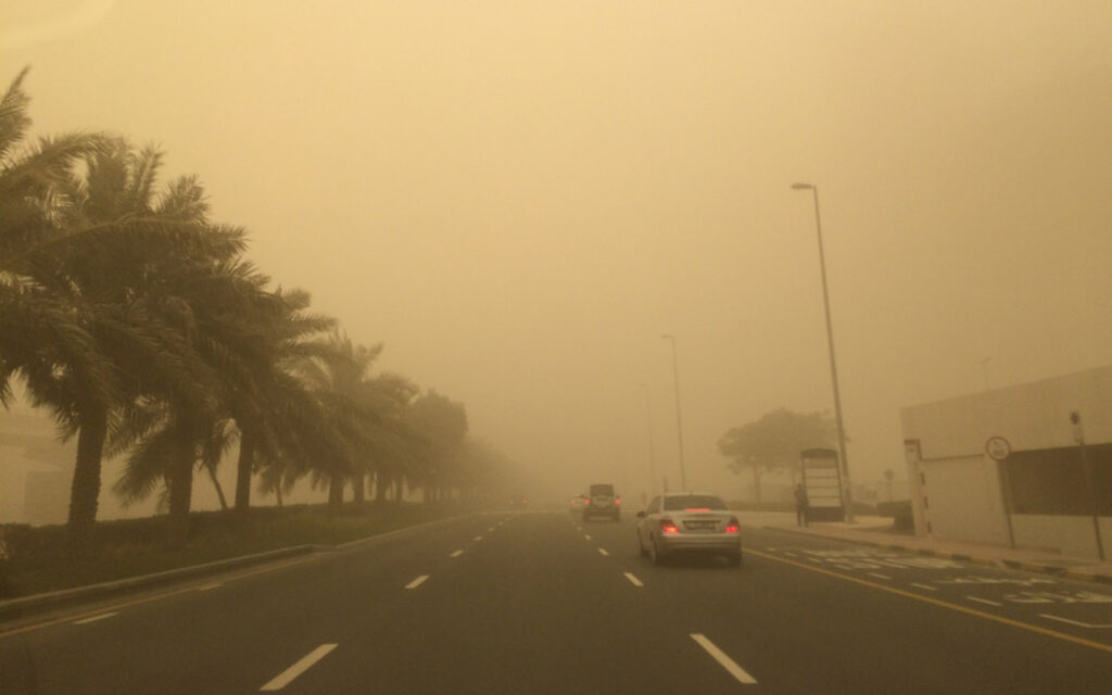 driver navigating low-visibility conditions in a Dubai sandstorm
