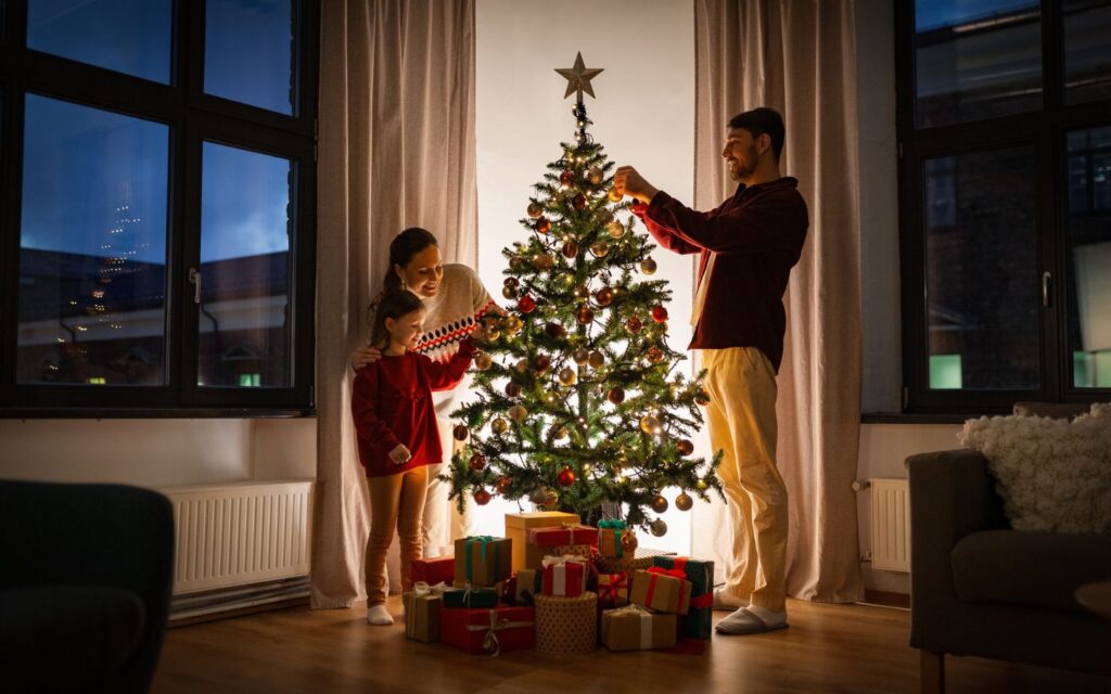 family decorating a real Christmas tree in Dubai living room